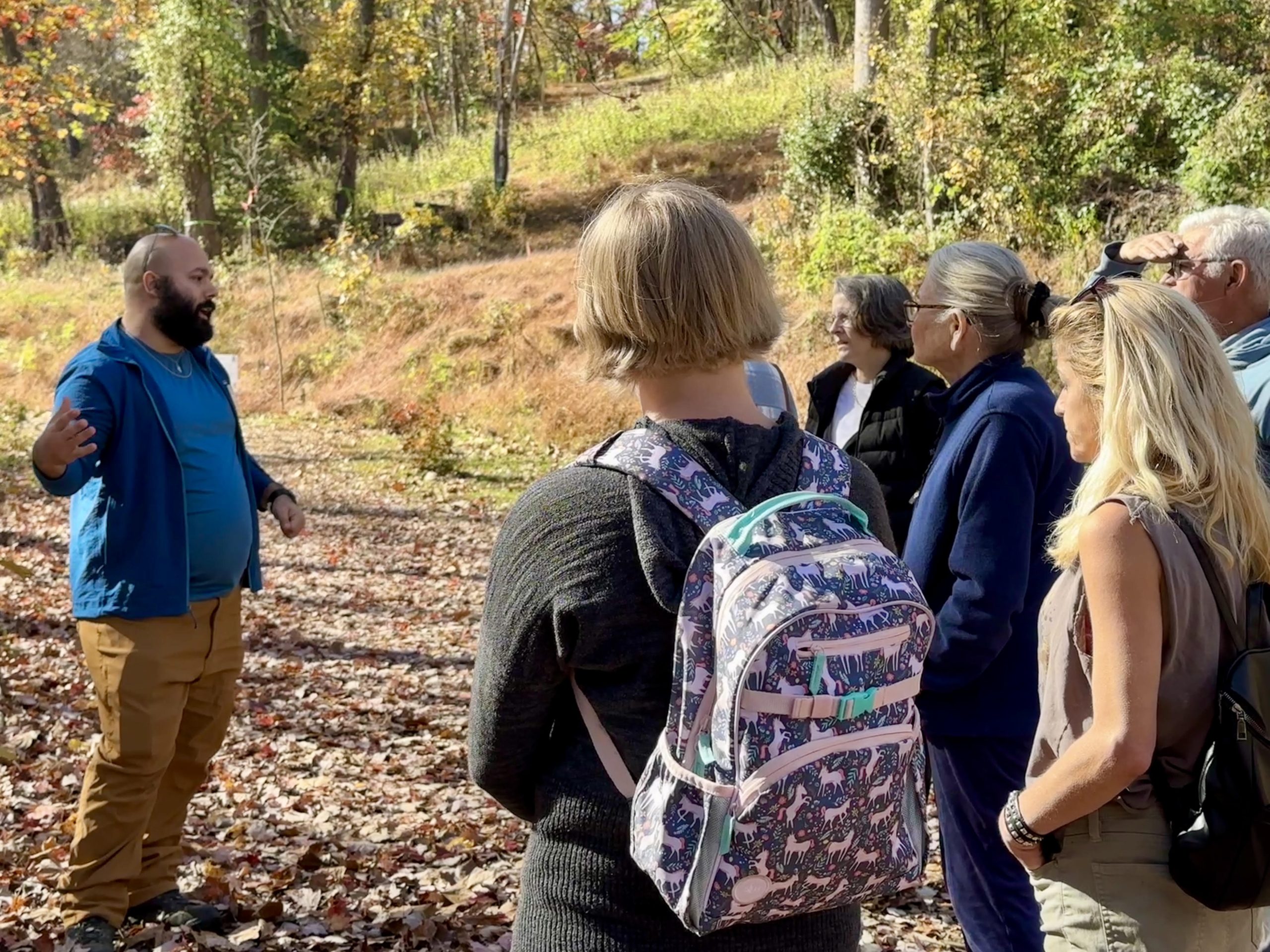 group of people on trail listening to leader