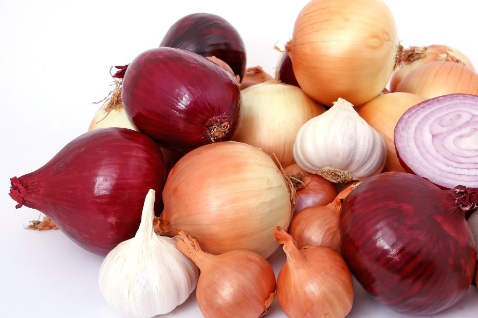 A multi-colored pile of onions and garlic